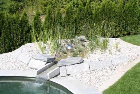 Steingarten mit kleinen Pflanzen und einem Wasserlauf in moderner Gartengestaltung.