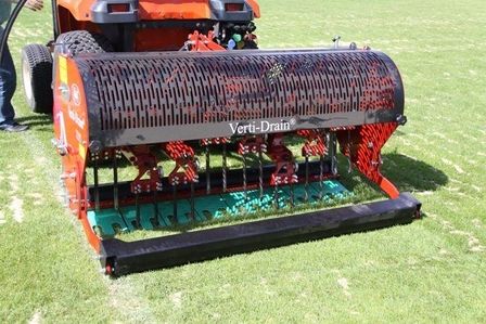 Traktor mit Rasenbelüfter im Einsatz.