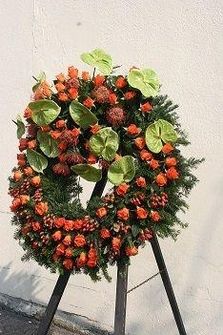 Blumengesteck aus orangefarbenen Rosen für eine Trauerzeremonie.